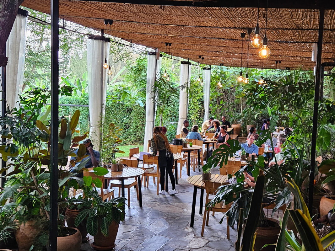 International professionals working together in a modern Kigali cafe — the expat community in Rwanda is small, well-connected and growing fast